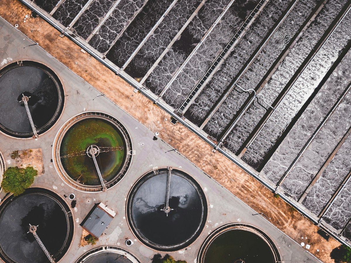 Aerial view of filtration ponds at an industrial wastewater treatment facility, secondary biology and tertiary polishing stages visible, Photo: Ivan Bandura / Unsplash